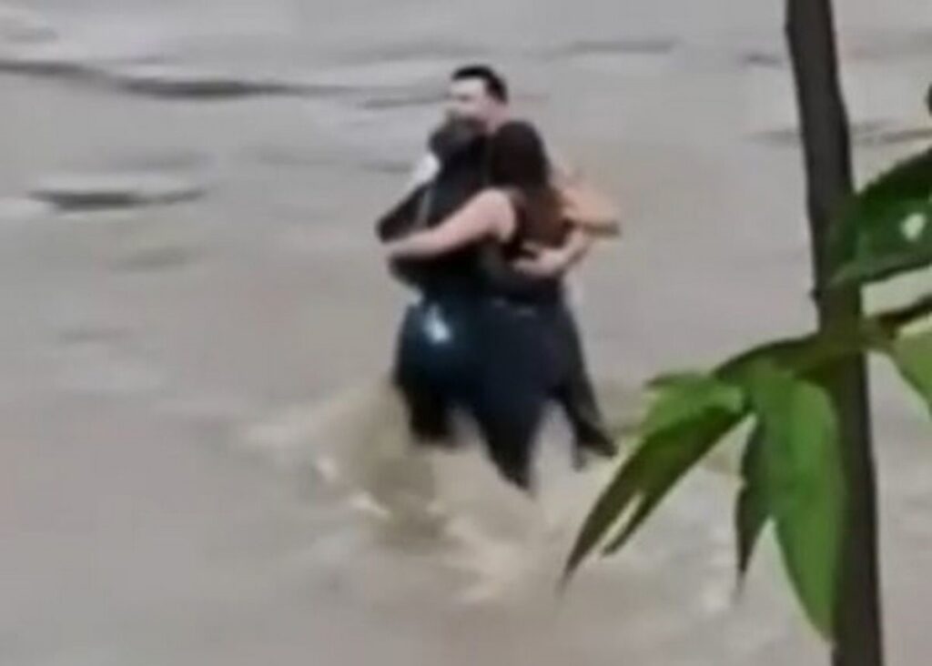Three friends sharing a hug before being engulfed by floods; shakes internet